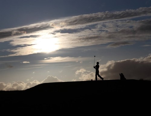Golfer Teeing Off At Dawn